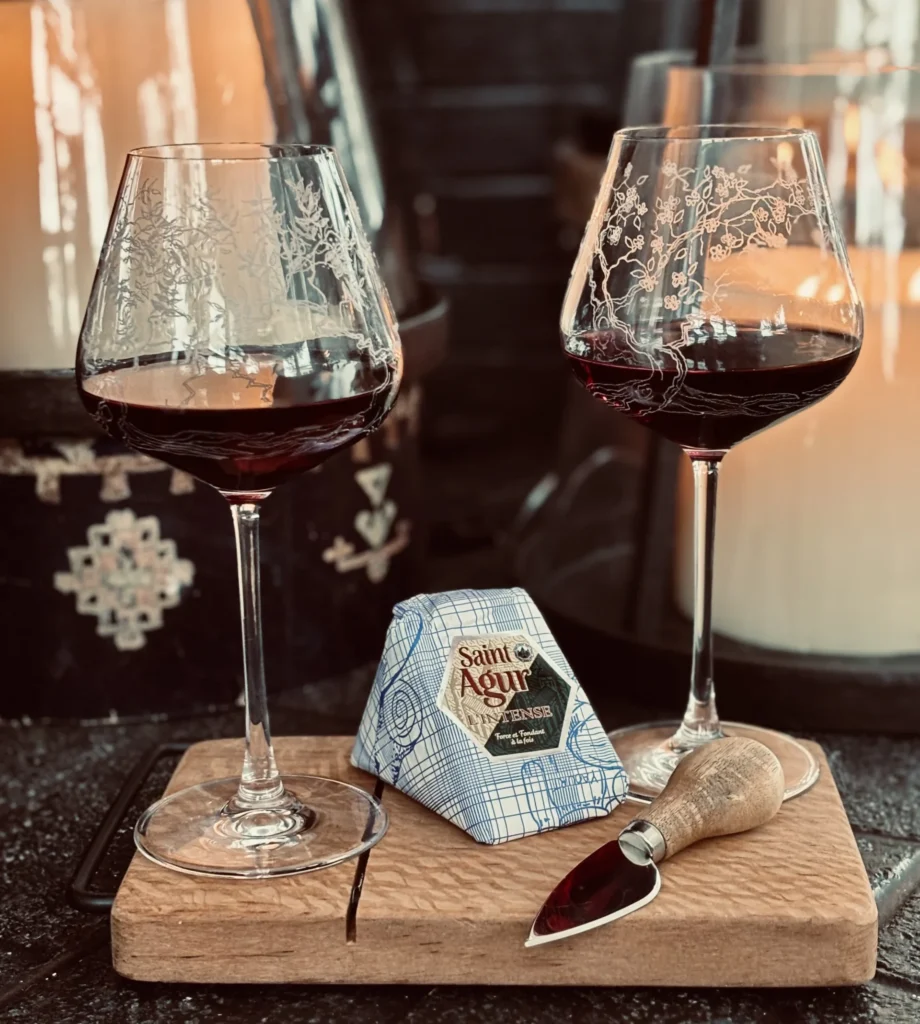 hand etched wine glasses, red wine, cheese on a wooden tray
